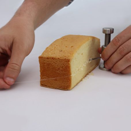 using the cake leveller cutting a layer into a slab of cake with the cake leveller